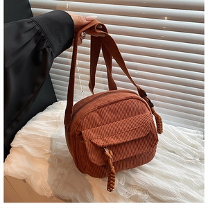 Détail du sac bandoulière en velours côtelé marron avec rabat texturé et tirette en corde