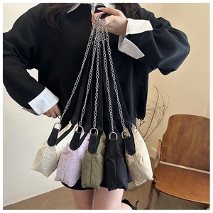 Detail showing five colors of pleated shoulder bags with metal chain and leather straps