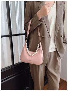 Detail of pink hobo bag with pearl chain strap and faux leather shoulder strap