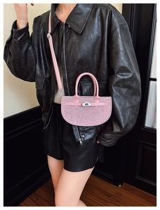 Detailed view of pink sequin crescent handbag with silver twist lock and leather handle