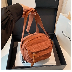 Sac bandoulière en velours côtelé caramel dans une boîte cadeau avec décorations