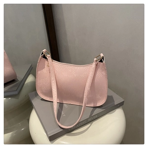 Detail of pink snake-embossed shoulder bag featuring elegant texture and gold hardware