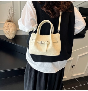 Détail du sac à main tissé blanc cassé avec sangle à boucle et bandoulière fine
