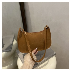 Detail of brown snakeskin texture underarm bag with gold zipper and shoulder strap