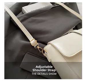 Dettaglio della tracolla regolabile con fibbia in metallo dorato su borsa in pelle beige