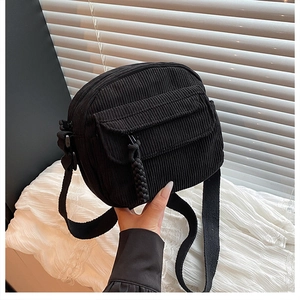 Détail de la texture du sac bandoulière en velours côtelé noir avec zip tissé et poche