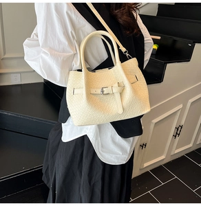 Detailed close-up of cream-white bucket bag featuring premium woven texture and strap