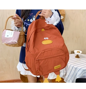 Detail view of cartoon duck backpack in orange with cute feet and zipper pocket