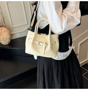 Détail du sac seau tissé blanc cassé avec boucle métallique et poignée ronde