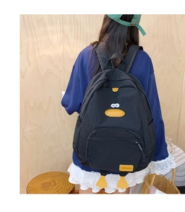 Rear view of a cartoon duck backpack in black nylon with cute 3D yellow feet details