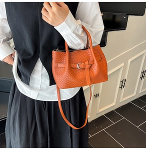 Détail du sac à main tissé orange avec ferrures argentées et bandoulière amovible