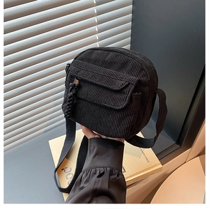 Détail du sac à bandoulière en velours côtelé noir montrant la texture côtelée