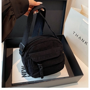 Détail du sac bandoulière en velours côtelé noir avec fermeture éclair et poche avant