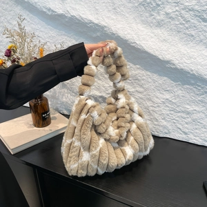 Close-up of plush faux fur striped tote bag with unique bubble knot handle detail