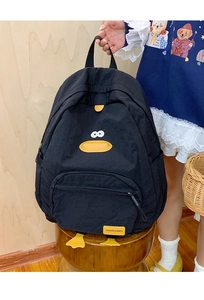 Detail of a black nylon backpack featuring cute yellow duck beak and hanging webbed feet