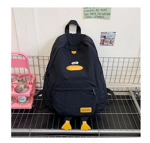 Detail of black nylon cartoon backpack featuring yellow duck patterns and pendant