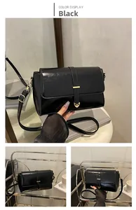 Dettaglio borsa a tracolla in pelle nera lucida con ornamento a cuore in metallo