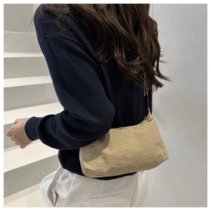 Close-up of hobo bag in light khaki wrinkled nylon with silver metal buckle details