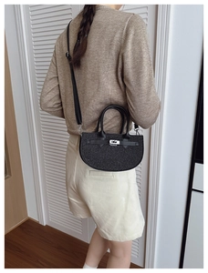 Detail of black glitter saddle bag with silver hardware and adjustable leather strap