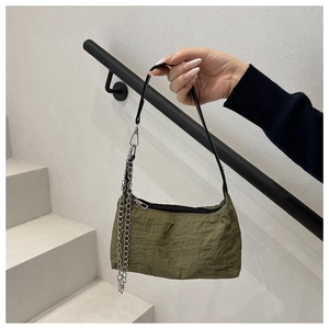 Detail of olive green crinkled fabric bag with silver chain and black strap
