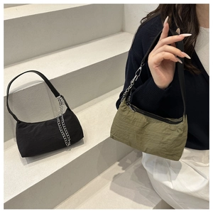 Detail of minimalist nylon shoulder bags with silver metal chains in black and olive green