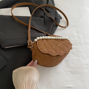 Brown shell-shaped crossbody bag with faux snakeskin texture and pearl trim accents