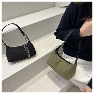 Detail of minimalist half-moon shoulder bags in black and olive green with metal chain