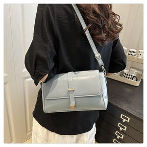 Détail du sac bandoulière bleu clair avec pointe cœur en métal sur vue latérale