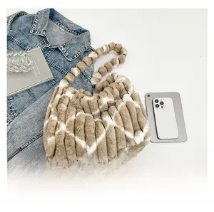 Detail of plush tote bag with heart patterns, knit handles and casual accessories