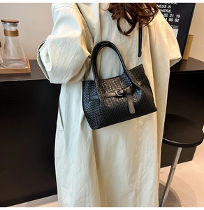 Dettaglio della borsa a mano intrecciata nera con fibbia e tracolla rimovibile