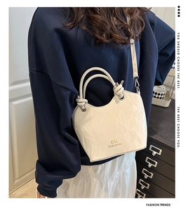 Détail de la bandoulière réglable et de la texture plissée de ce sac à main blanc