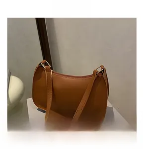 Macro shot of brown faux leather texture and golden metal buckle on the shoulder bag