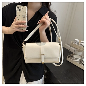 Dettaglio di una borsa a tracolla beige in pelle PU con fibbia in metallo dorato a cuore