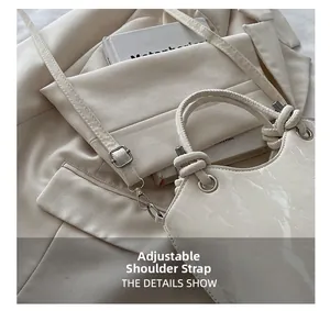 Détail du sac seau crème montrant la bandoulière réglable et la boucle en métal argenté