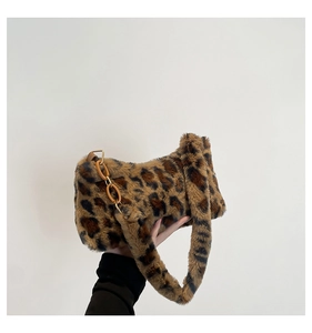 Détail d'un sac à main en peluche léopard avec une chaîne décorative orange vif