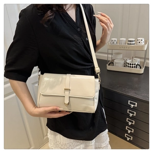 Sac bandoulière beige chic avec boucle cœur porté par un mannequin dans un intérieur