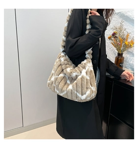 Detail of plush tote bag with beige striped faux fur and thick shoulder strap on model