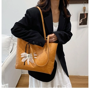 Orange large capacity tote bag with flower pendant and wrinkled leather texture
