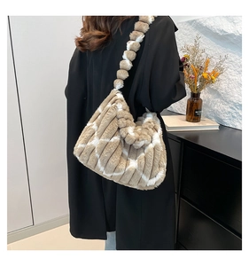 Detail of plush tote bag with beige striped faux fur and unique pom-pom shoulder strap