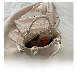 Vue de dessus d'un sac seau crème montrant sa grande capacité pour téléphone et maquillage