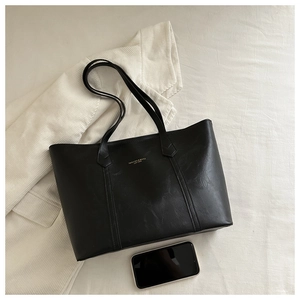 Détails du grand sac cabas noir en cuir avec lettrage doré et coutures fines
