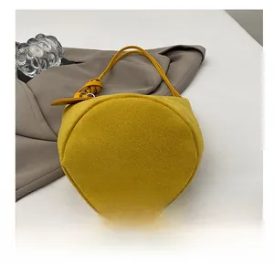 Dettaglio della base resistente e del feltro giallo della borsa a secchiello minimalista