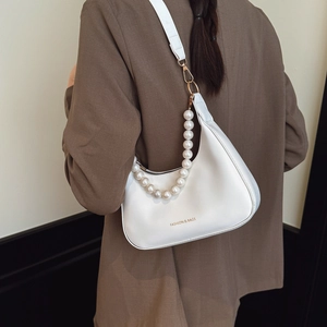 White crescent underarm bag with gold logo lettering and decorative white pearl chain strap
