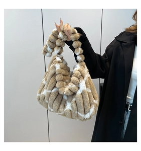 Close-up of khaki striped plush tote bag with unique soft faux fur ball handle design