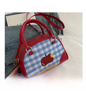 Detailed shot of red apple plaid handbag with blue fabric and silver hardware