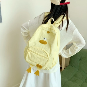 Cartoon duck yellow backpack for students with 3D eyes and feet in a cozy room setting