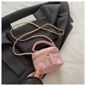 Detail of pink quilted mini crossbody bag with gold chain strap and dual zipper closure