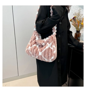 Detail of pink and white faux fur tote bag featuring soft plush texture and pom-pom accent