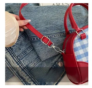 Close-up of adjustable strap and silver buckle on a vintage checkered crossbody bag
