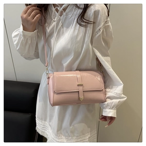 Détail d'un sac bandoulière rose avec boucle cœur dorée et sangle décorative en cuir